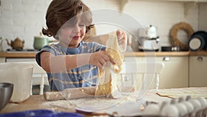 Little kid learns to cook boy rolls and plays with dough