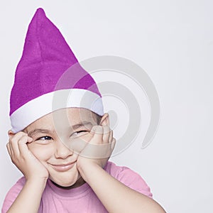 A little kid making funny annoyed face. Annoyed Christmas Boy in Santa Hat