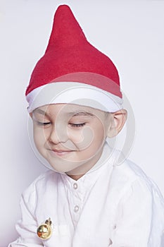 A little kid making a funny annoyed face. Annoyed Christmas Boy in Santa Hat. A really serious and handsome kid