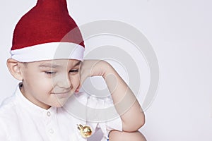 A little kid making a funny annoyed face. Annoyed Christmas Boy in Santa Hat. A really serious and handsome kid