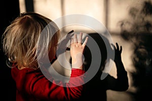 Little Kid Making Shadow Puppets with Fingers on the Wall of her Home