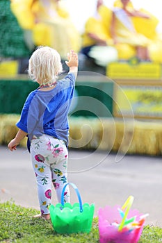 Little Kid at Parade Waving at People on Float