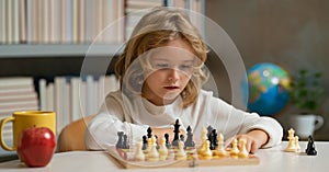 Little kid play chess in school class. Child boy playing board game. Thinking child brainstorming and idea in chess game