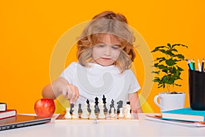 Little kid play chess. Thinking child. Chess game for kids. Intelligent, smart and clever school boy. Kid with chess on