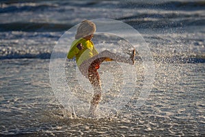 Little kid play in water and making splash. Child have fun with drops. Summer kid play in waves sea, kid play in sea and