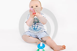 Little kid playing with baby pyramid on white background