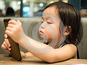 Little kid is playing with mobile phone