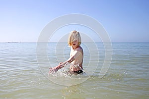 Little Kid Playing and Splashing in the Ocean Water