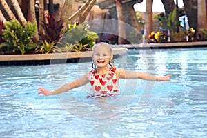Little Kid Playing in Tropical Resort Swimming Pool