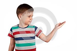 Little kid pointing on something, isolated on white background. Copy space.