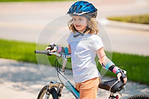 Little kid riding a bike in summer park. Children learning to drive a bicycle on a driveway outside. Kid riding bikes in