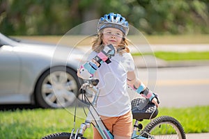 Little kid riding a bike in summer park. Children learning to drive a bicycle on a driveway outside. Kid riding bikes in