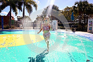 Little Kid Running through Water Sprinklers at Outdoor Splash Park