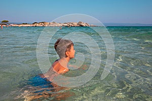 Little kid swimming in sea at Greece