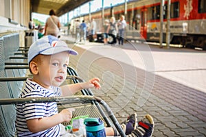 Little kid in a train station  ready to travel again