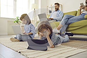 Little kid watching a video on a tablet while the rest of his family are using their own devices