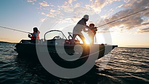 Little kids are angling from a boat with their father