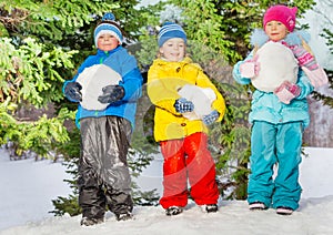 Little kids with big snowballs in the park