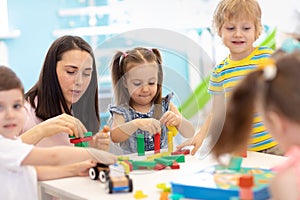 Little kids build block toys at playschool or daycare. Kids playing with color blocks. Educational toys for preschool