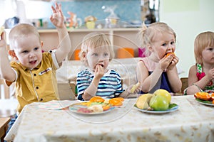 Little kids eating in kindergarten