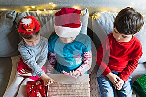 Little kids girls, boy have video call, onine virtual conference in laptop.Red Christmas santa claus,elf hat. Congratulations,