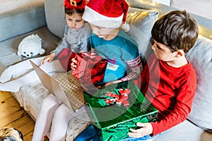 Little kids girls, boy have video call, onine virtual conference in laptop.Red Christmas santa claus,elf hat. Congratulations,