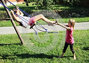 Little kids - girls playing on swing