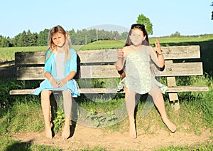 Little kids - girls sitting on a bench