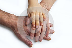 Little kids grandson hands on old hands of grandparents. Concept assistance, patronage and generation. National Senior Citizens photo