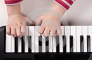 little kids hands playing piano top view, education concept