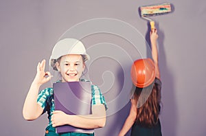Little kids in helmet with tablet and roller. engineering idea. Future career. Painting wall. Foreman inspector. Labor