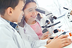 Little kids learning chemistry in school laboratory