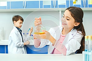 Little kids learning chemistry in school laboratory study