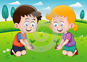 Little kids is planting small plant in garden