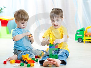 Little kids play with building bricks in preschool