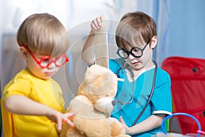 Little kids play doctor with plush toy