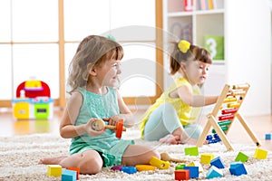 Little kids playing with abacus and constructor toys in kindergarten, playschool or daycare center