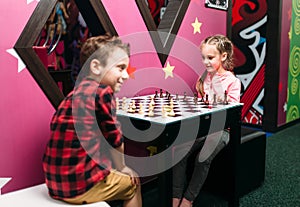 Little kids playing chess in entertainment center