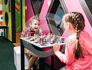 Little kids playing chess in entertainment center