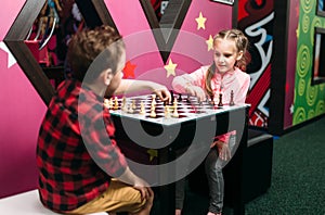 Little kids playing chess in entertainment center