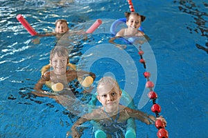 Little kids with swimming noodles