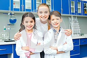 Little kids with teacher in school laboratory team