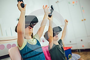 Kids in virtual reality headsets playing video game at home