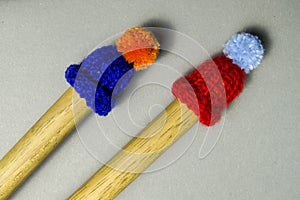 little knitted hats sit on drum sticks photo