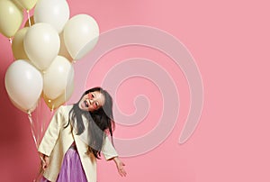 Little Korean baby girl in yellow fashion jacket and purple dress with balloons celebrate happy smiling screaming