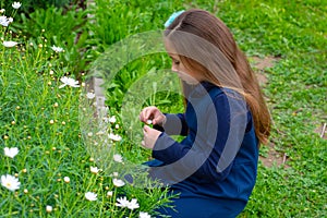 Little latina girl in garden contemplating flowers