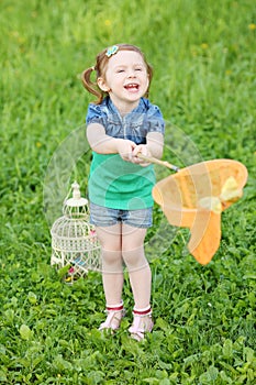 Little laughing girl holds orange butterfly net on