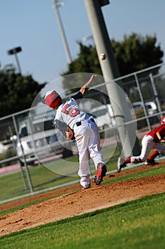 Little league pitcher throwing to first