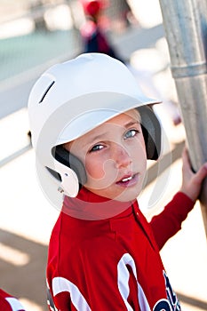 Little league baseball player in dugout