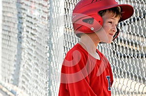 Little league baseball player in dugout